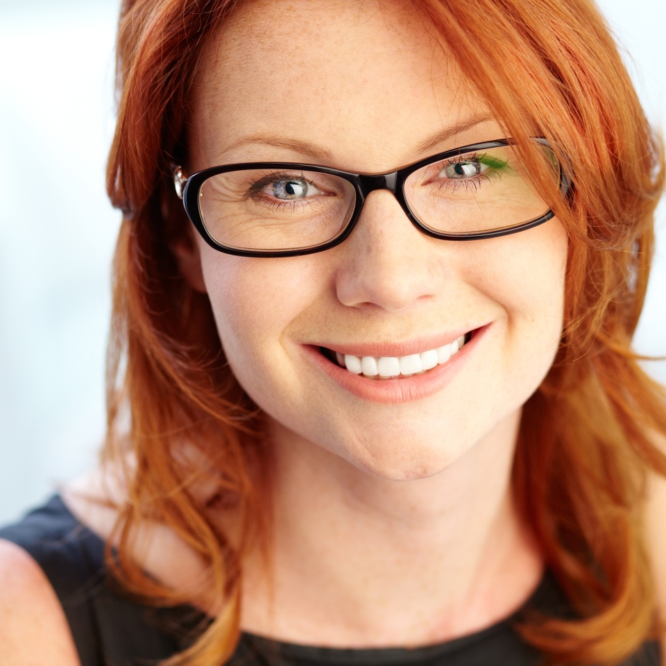 Close-up shot of a wonderful red-haired woman looking at camera