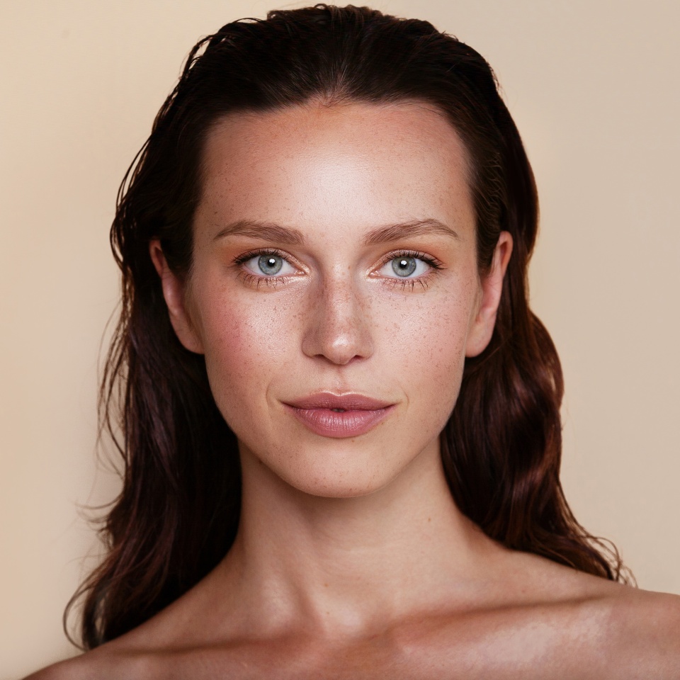 Beauty woman portrait. Beautiful spa model girl with perfect fresh clean skin. Youth and skin care concept. Beige background. Nude makeup