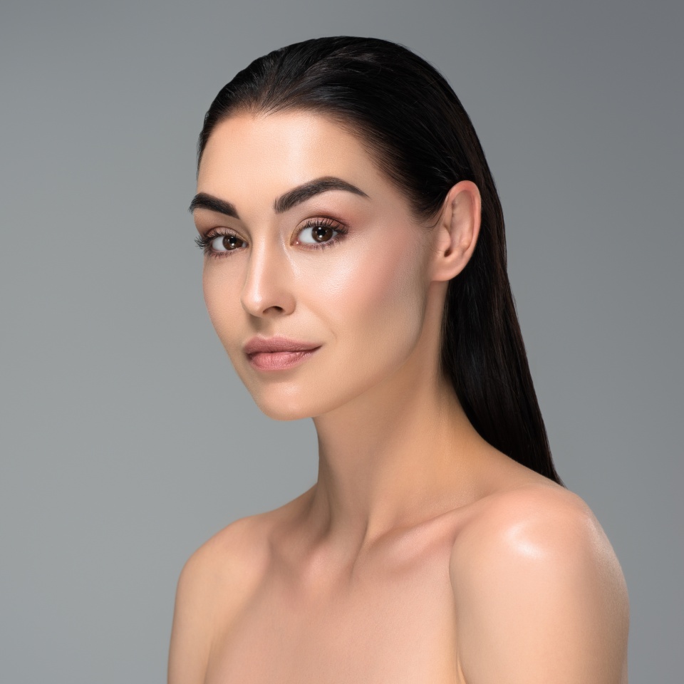 portrait of beautiful sensual naked brunette woman looking at camera isolated on grey