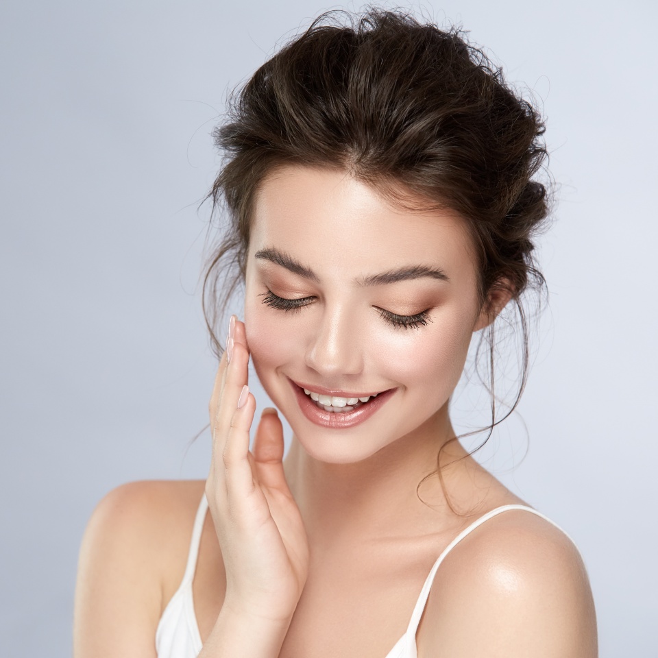 cute girl with natural make-up smiling and looking down, young and healthy woman facial care, cosmetology and dental concept
