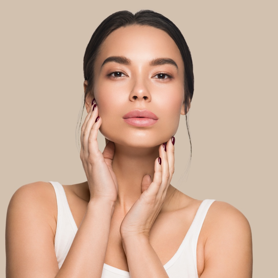 Beautiful woman close up face asian girl with clean fresh healthy skin. Color background. Brown