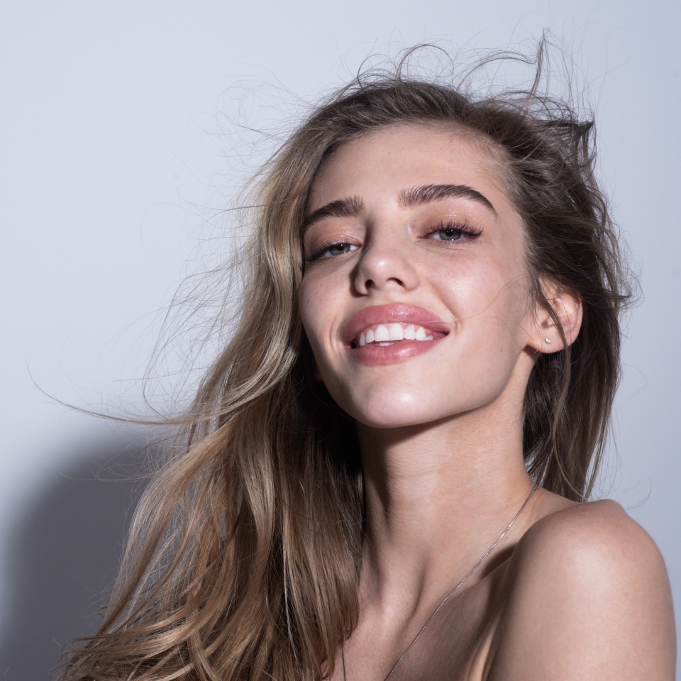 Portrait of a young beauty happy smiling woman. Portrait of happy young girl on gray background.