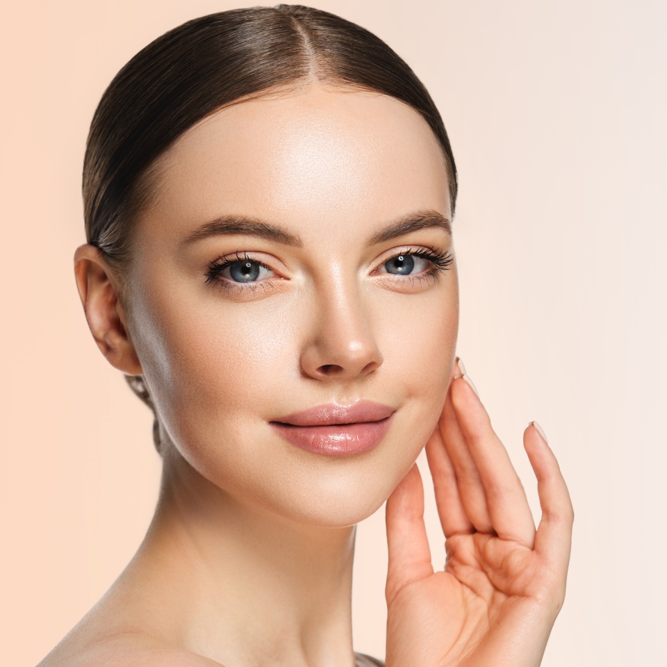 Beautiful young woman with clean fresh skin on face . Girl facial treatment . Cosmetology , beauty and spa .