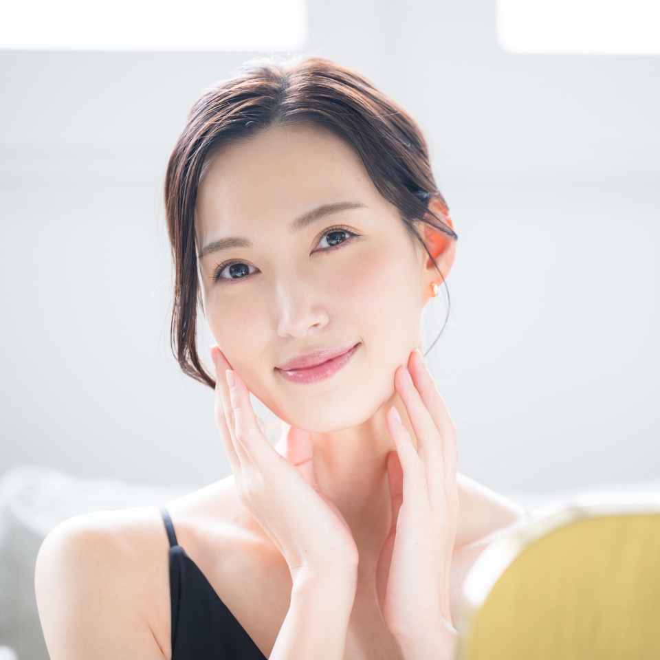 Close-up camera view of a woman touching her beautiful skin with both hands, concerned about dry cheeks and skin care.