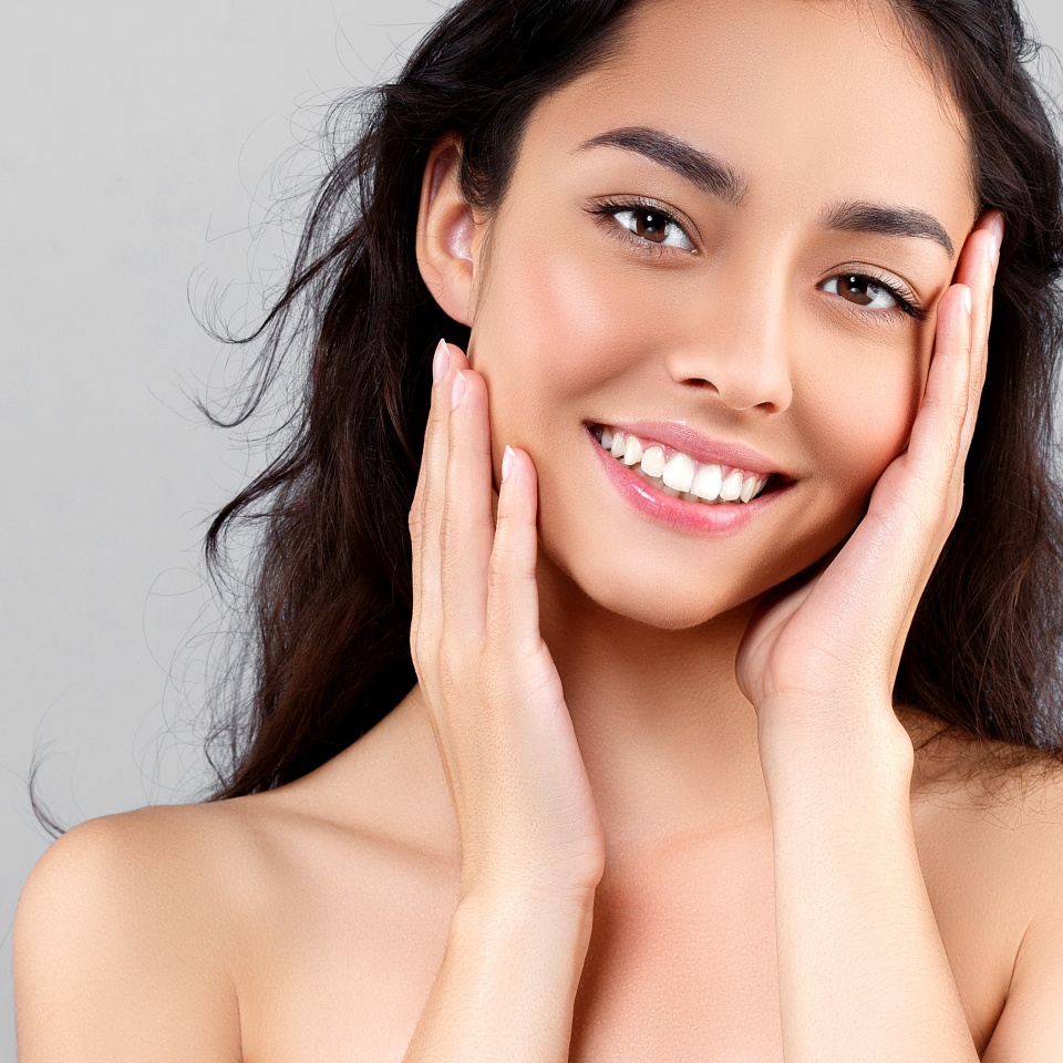 Woman beauty face portrait isolated on gray with healthy skin and white teeth smile