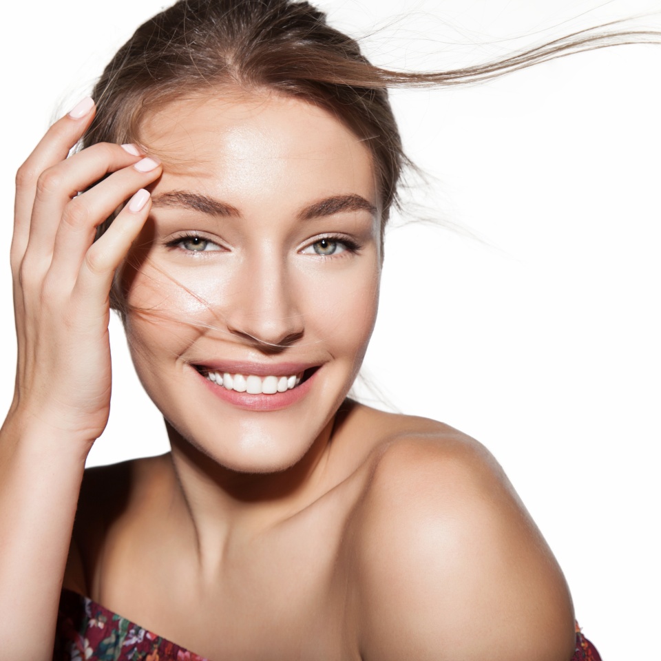 Beautiful woman portrait with hair flies. Female face close up studio portrait, isolated on white. Girl with clean skin and fresh daily make-up. Concept of cosmetology and beauty industry.