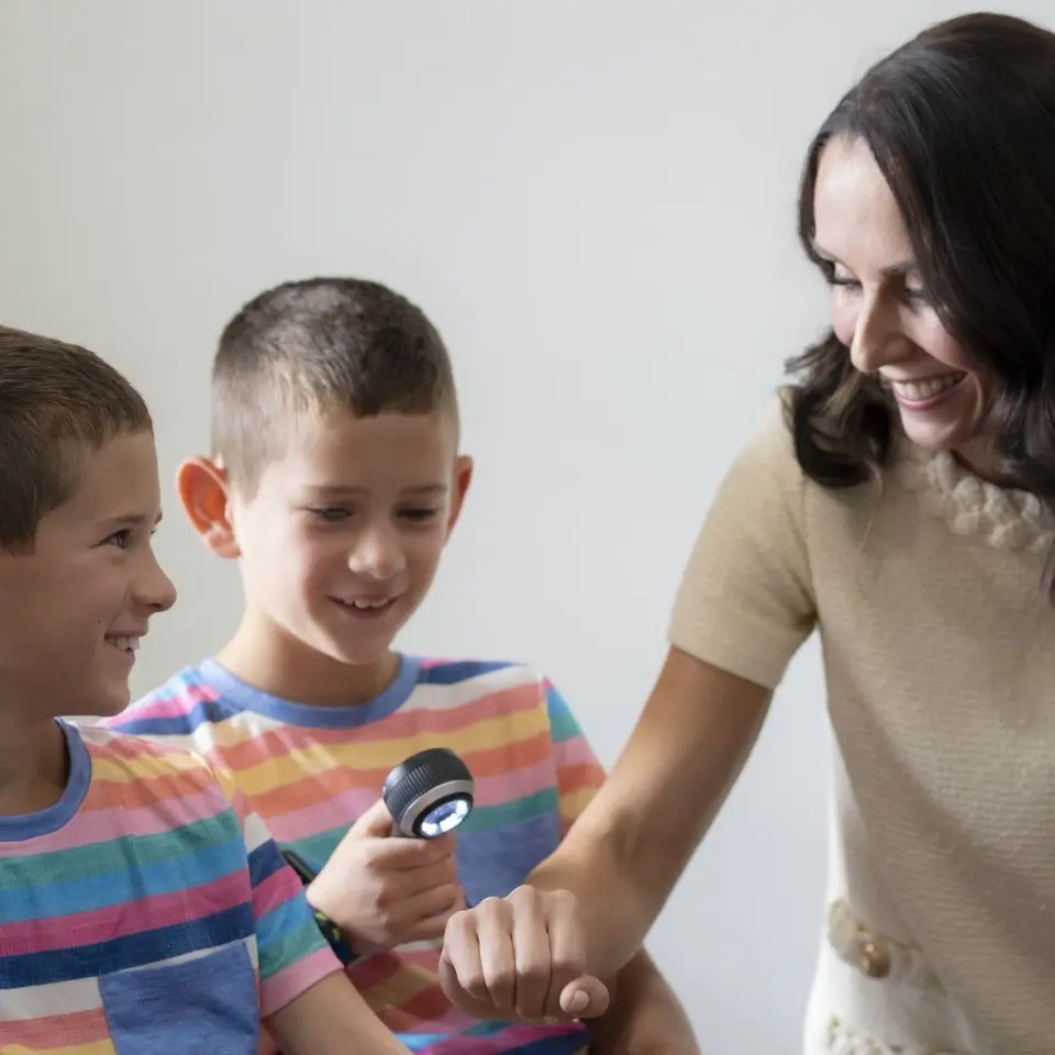 Young boy examining Dr. Kristine Zitelli’s skin