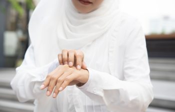 Muslim woman scratching her hand skin; dry skin, allergic skin inflammation, body care, fungus inflammation, dermatology disease, eczema, rash, skin care concept; young adult Islamic woman model
